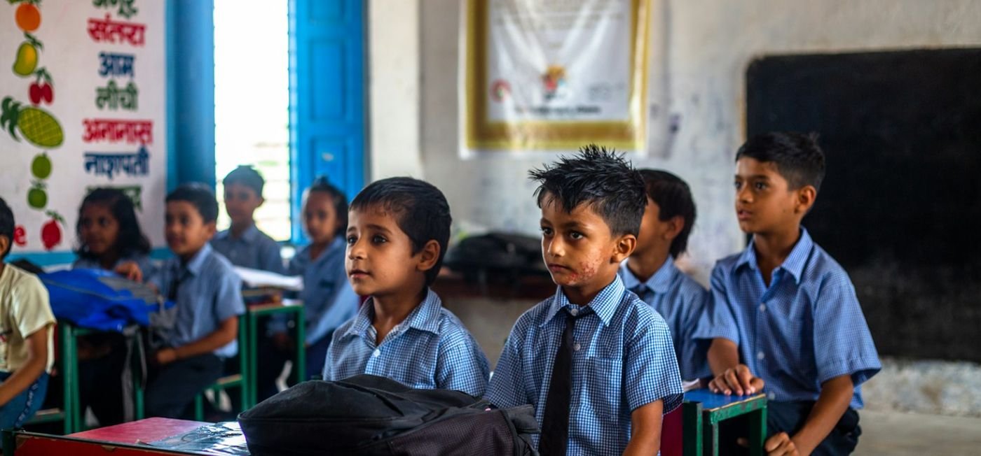 Children in blue uniforms listening in a government-school classroom in India (representative image)